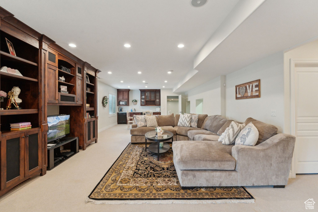 Living area featuring light carpet, recessed lighting, bar area, and baseboards
