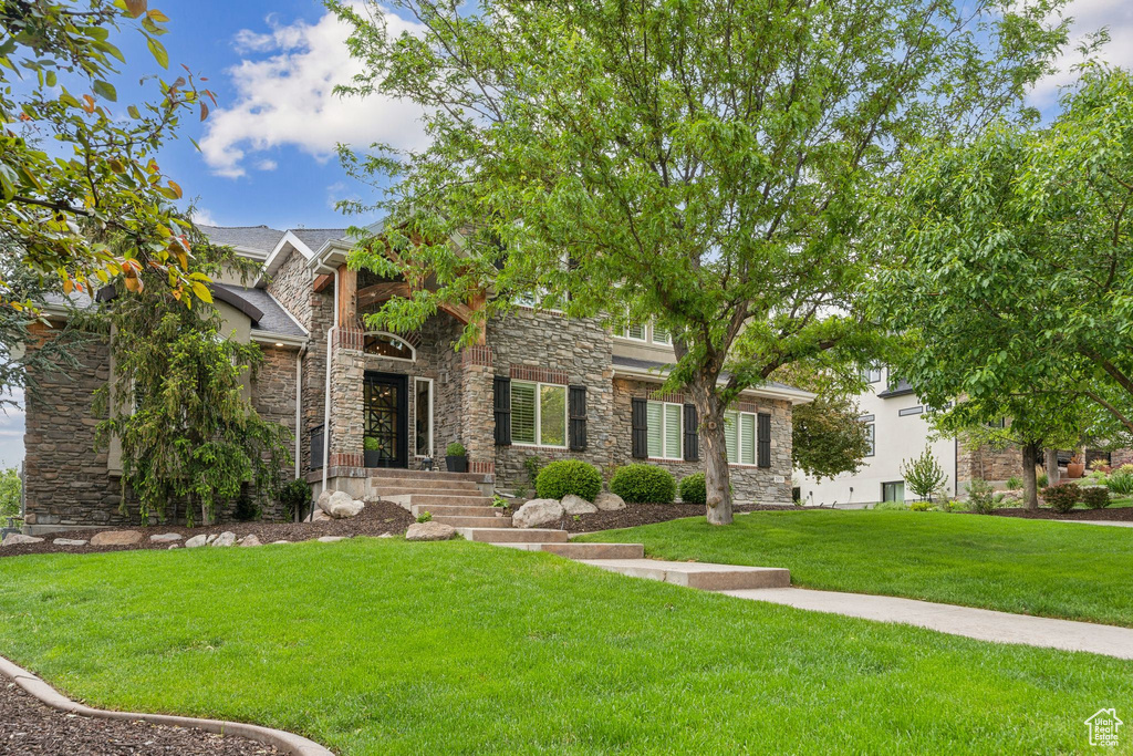 View of front of house with stone siding and a front yard