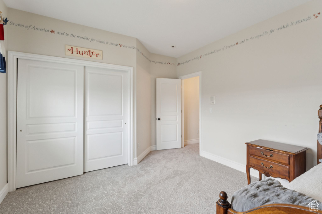 Bedroom featuring baseboards, carpet, and a closet