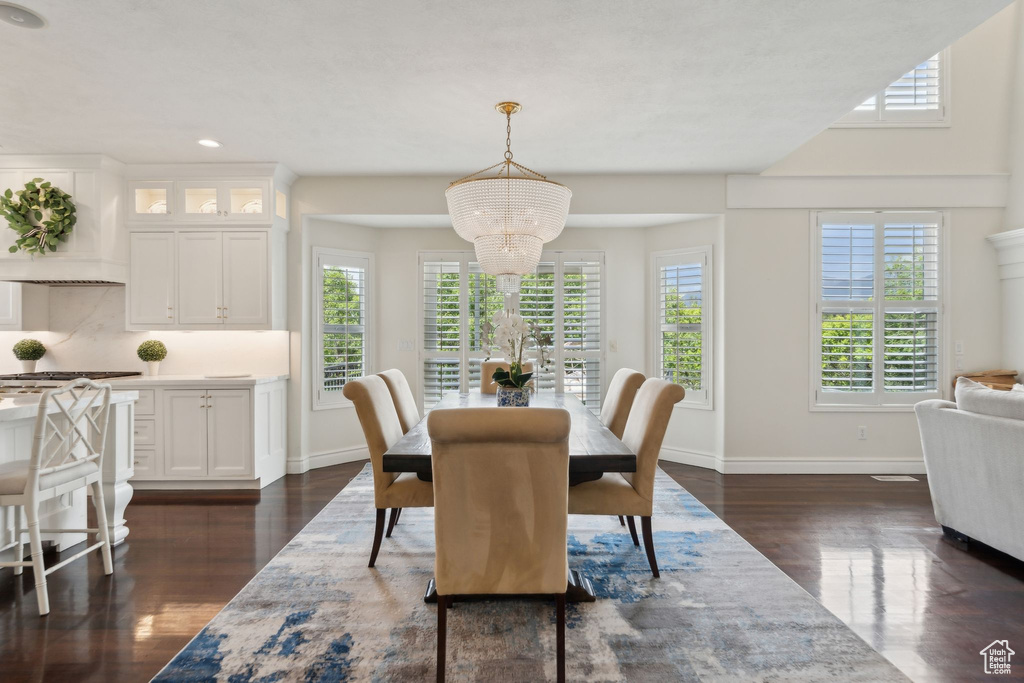 Dining room featuring dark wood finished floors, recessed lighting, baseboards, and a chandelier