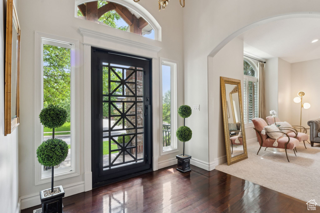 Entrance foyer featuring arched walkways, dark wood-type flooring, and baseboards