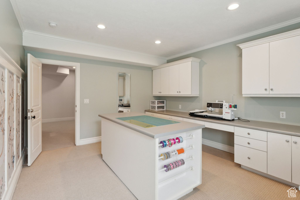 Kitchen with crown molding, light carpet, recessed lighting, white cabinetry, and a center island