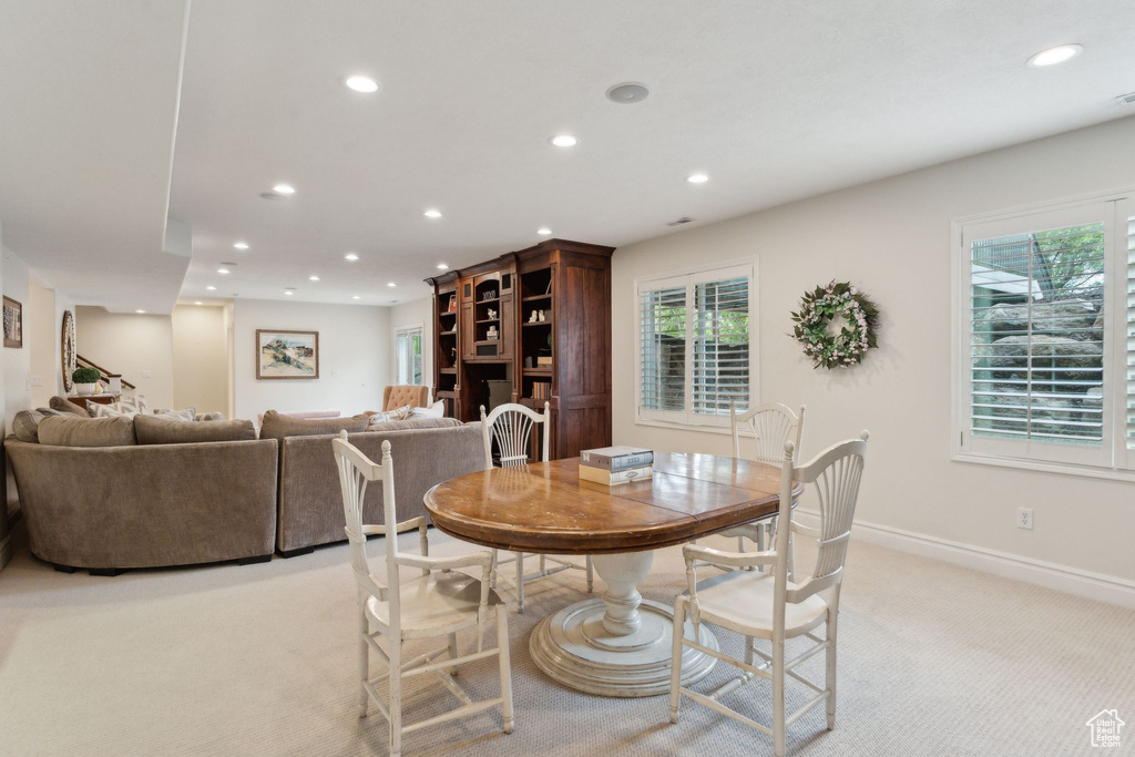 Dining space with light carpet, recessed lighting, healthy amount of natural light, and baseboards