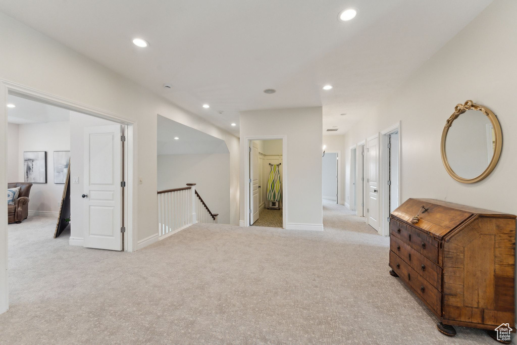 Hallway featuring an upstairs landing, light carpet, recessed lighting, and baseboards