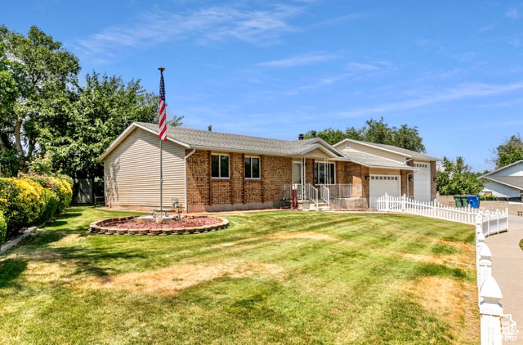 Ranch-style house featuring an attached garage, brick siding, and driveway