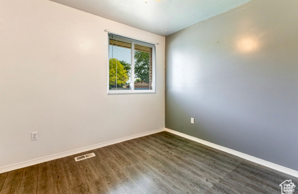 Unfurnished room with dark wood-style flooring and baseboards
