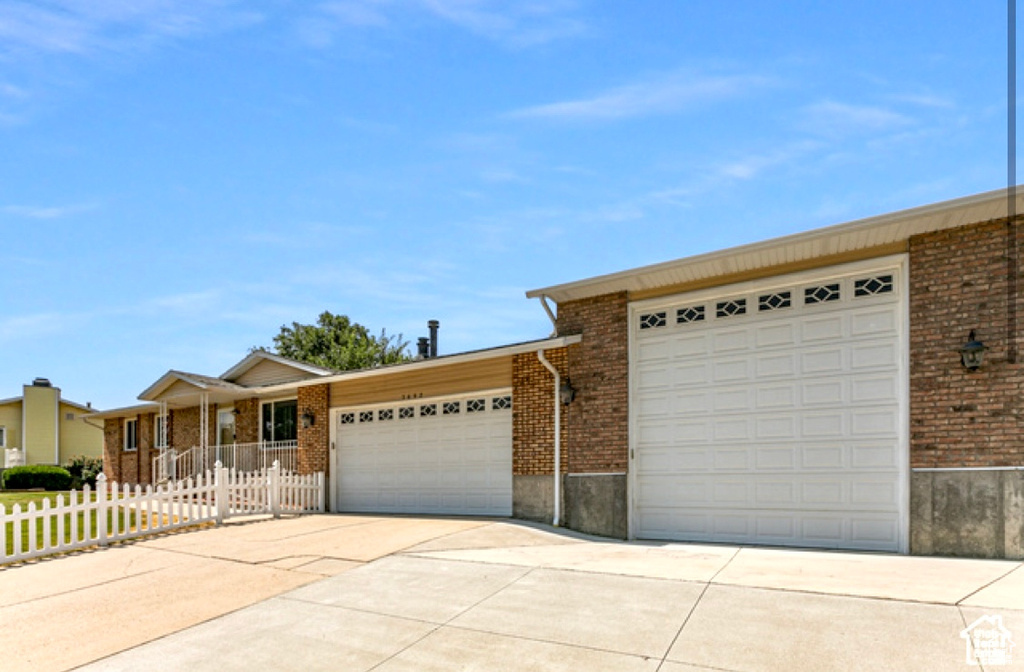 Single story home with an attached garage, brick siding, and driveway