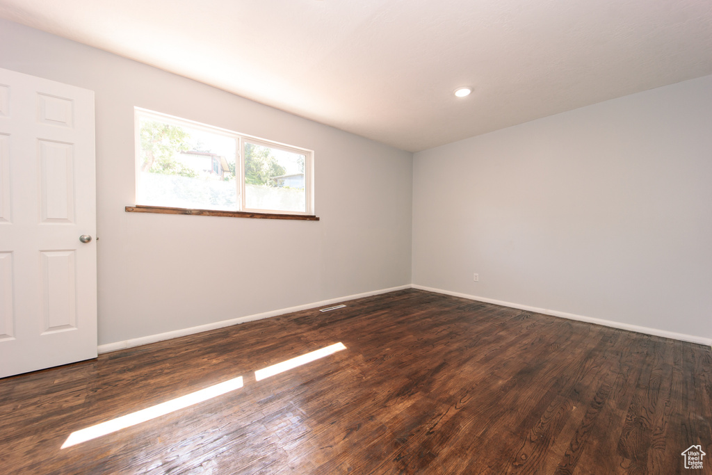 Spare room with dark wood-type flooring, baseboards, and recessed lighting
