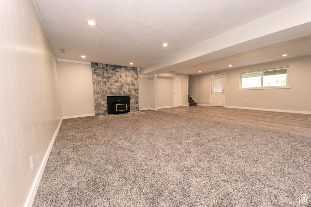 Unfurnished living room featuring carpet floors, stairway, recessed lighting, and baseboards