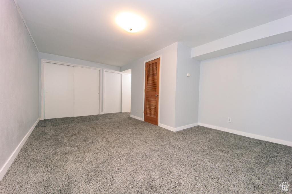 Unfurnished bedroom featuring carpet, multiple closets, and baseboards