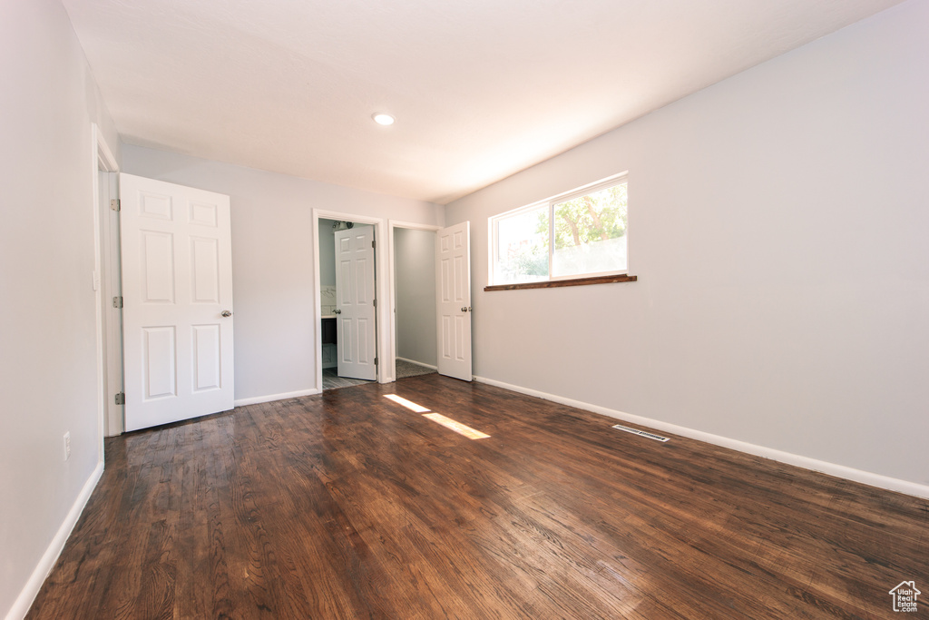 Unfurnished bedroom with dark wood-type flooring, baseboards, and recessed lighting