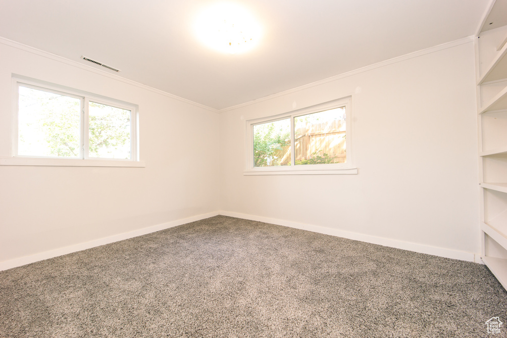 Spare room featuring carpet, baseboards, and ornamental molding