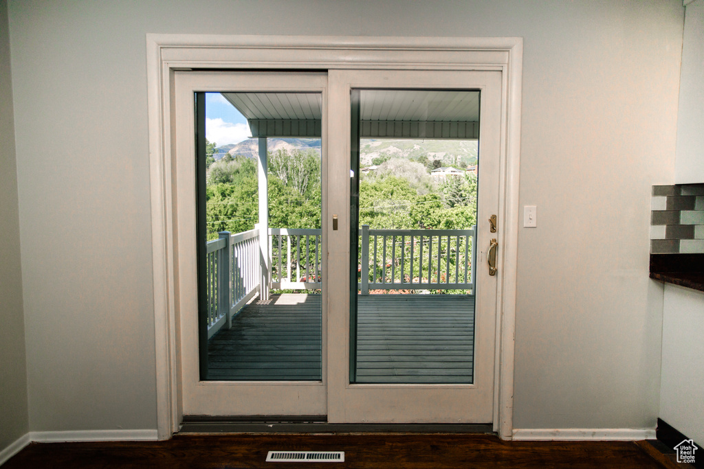 Doorway to outside with baseboards and dark wood-style flooring