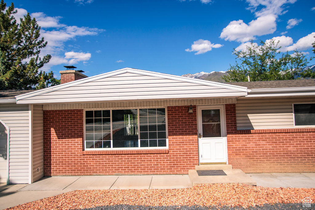 View of front of home with a chimney and brick siding