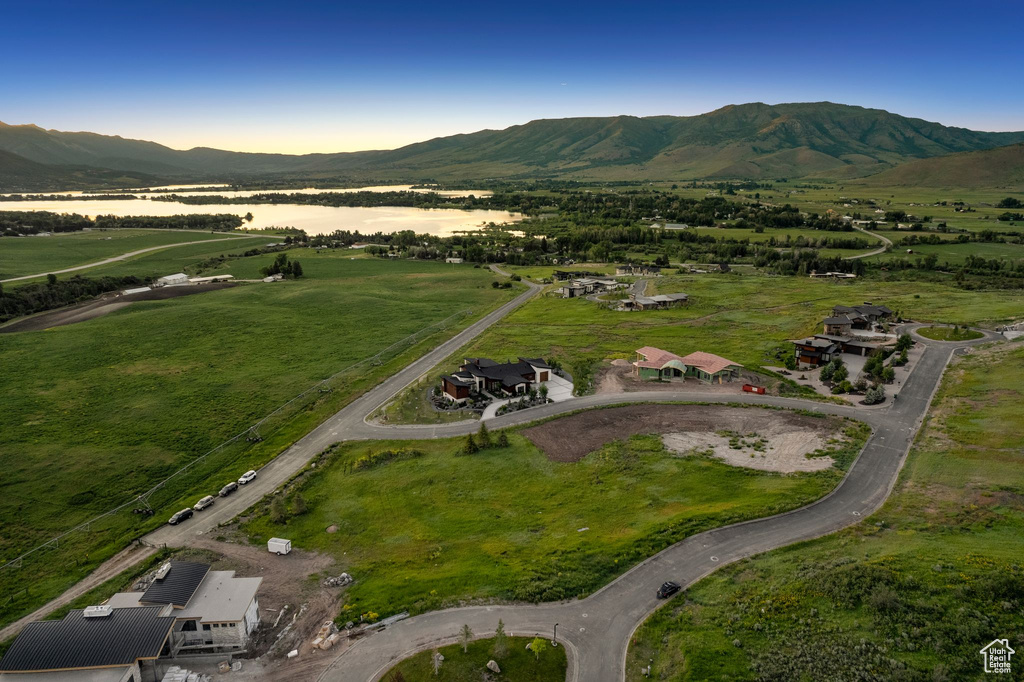 Aerial view of property and surrounding area featuring a mountainous background and rural landscape