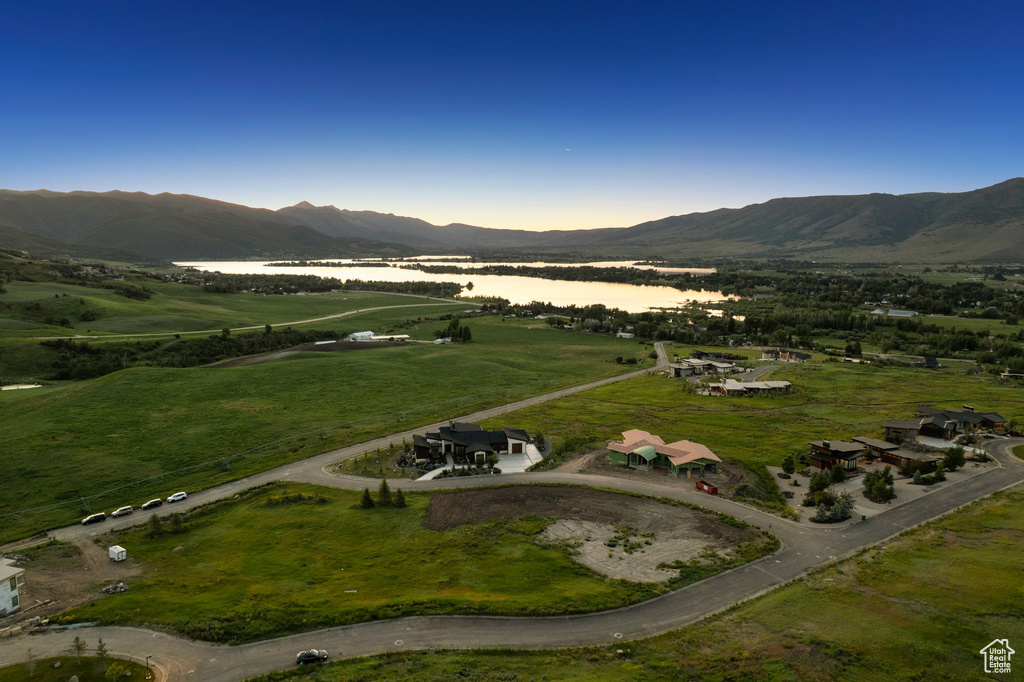 Aerial view of property and surrounding area featuring a water and mountain view