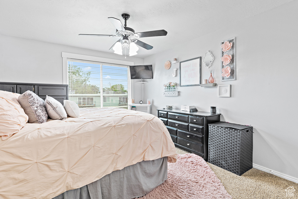 Bedroom featuring a ceiling fan, carpet, and baseboards