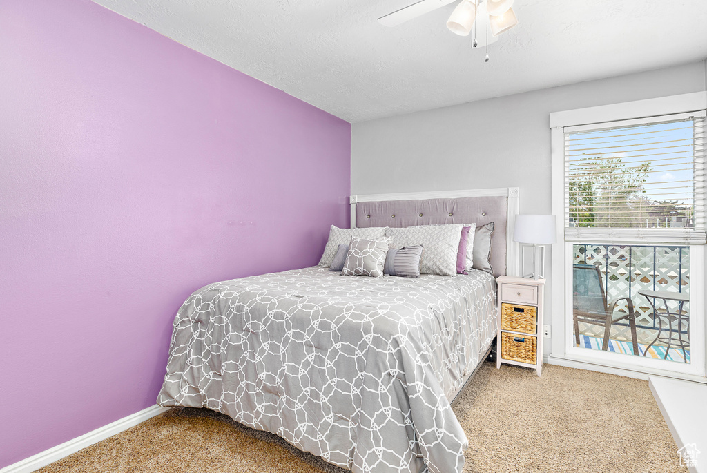 Carpeted bedroom featuring ceiling fan and baseboards