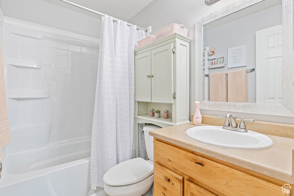 Full bath with toilet, shower / bath combo, and vanity