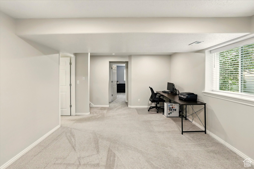 Carpeted office space with baseboards