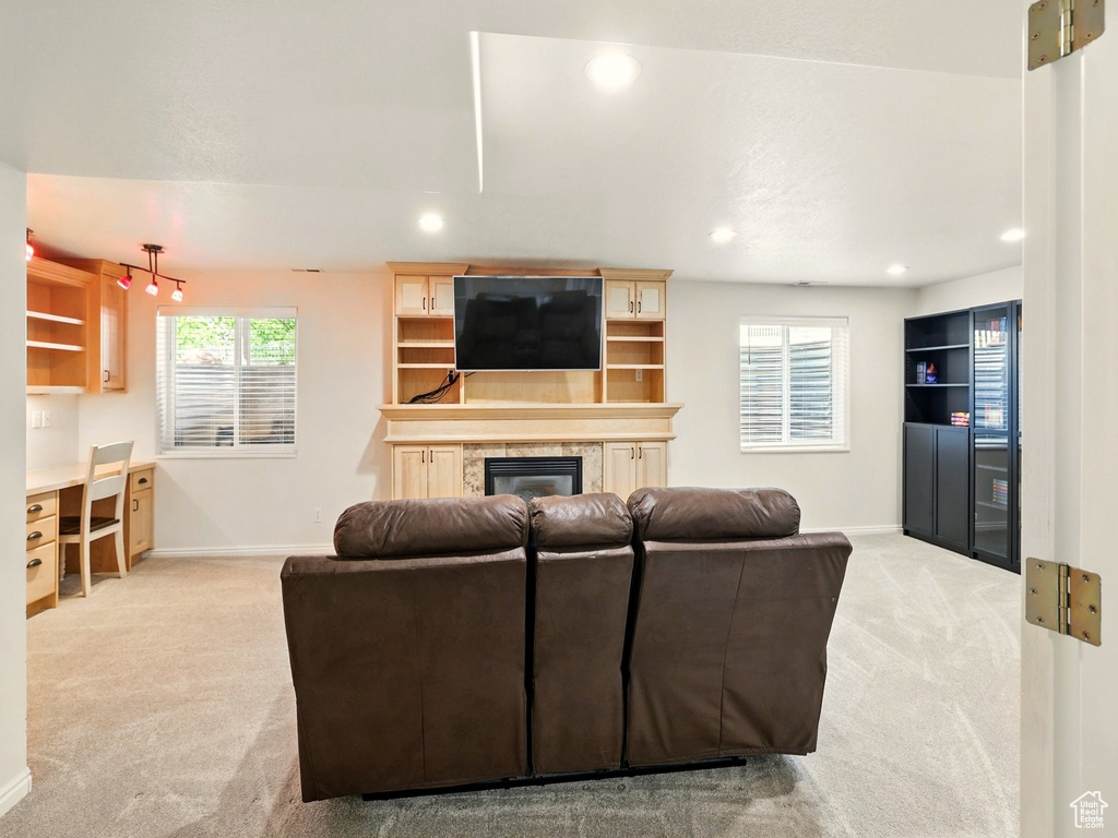 Living room featuring carpet, a high end fireplace, baseboards, and recessed lighting