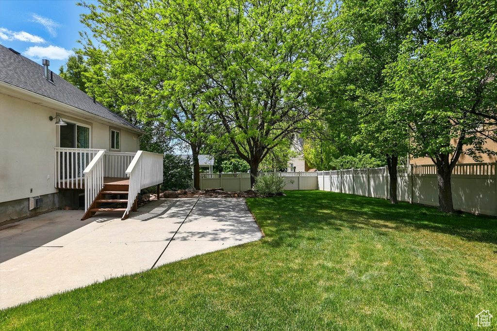 View of yard with a patio and a wooden deck
