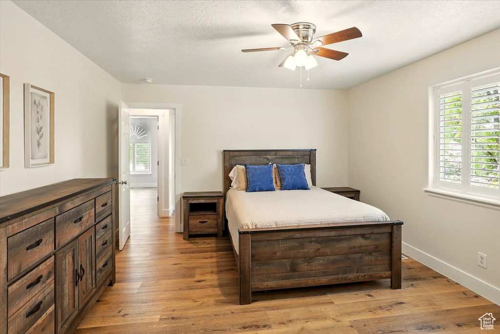 Bedroom with light wood-style flooring, baseboards, and ceiling fan