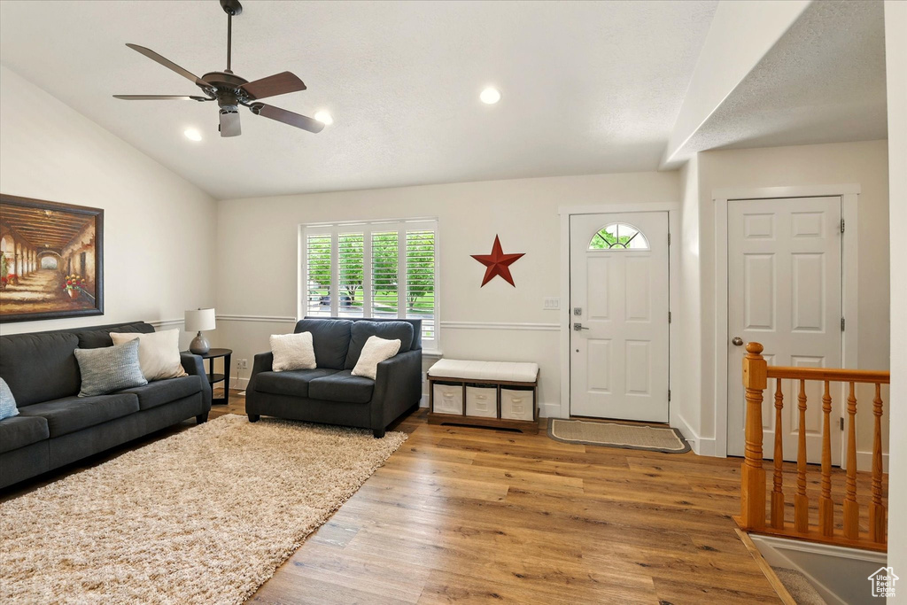 Living room with vaulted ceiling, wood finished floors, ceiling fan, recessed lighting, and baseboards