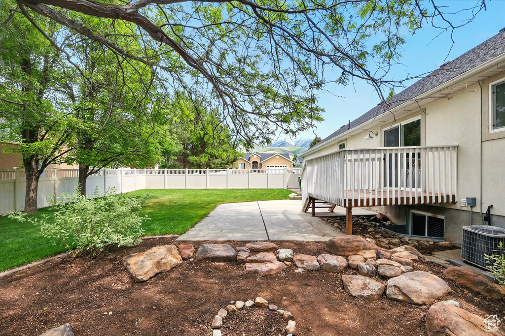 View of yard featuring a patio, a deck, and central AC unit