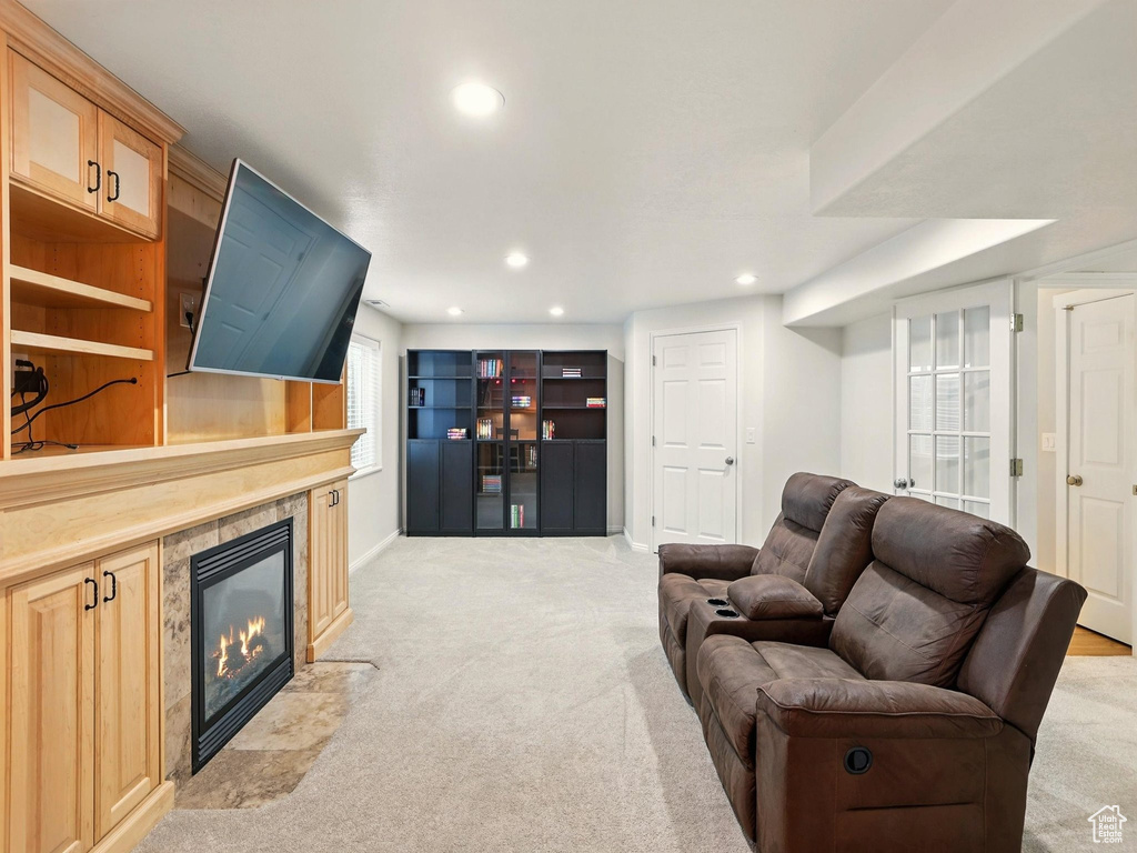 Living area featuring light carpet, a tiled fireplace, recessed lighting, and baseboards