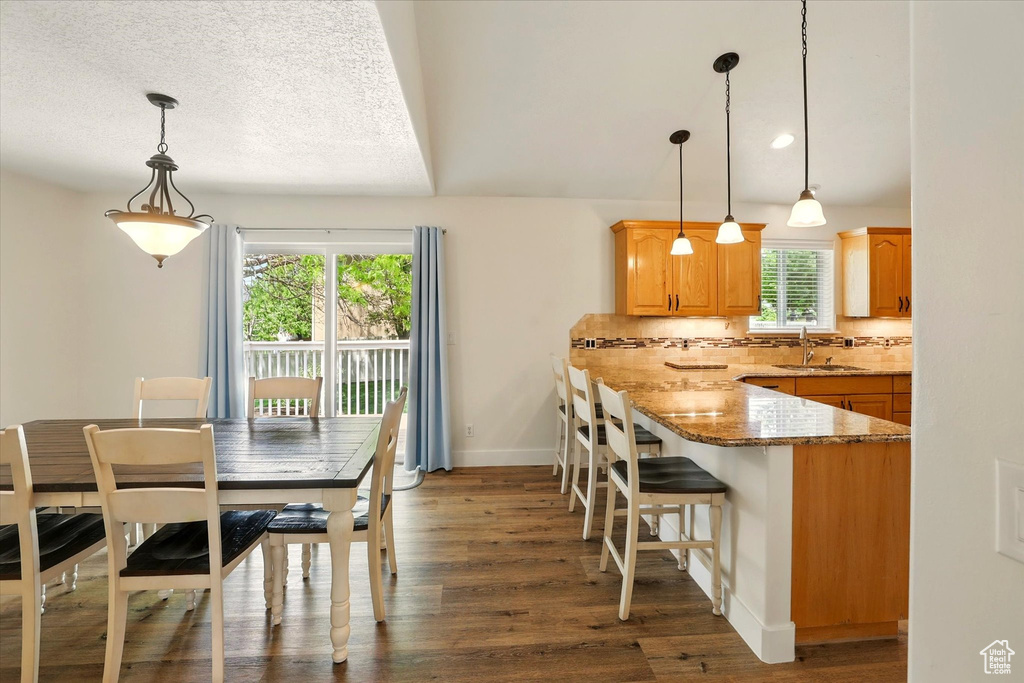 Dining space with dark wood-style floors and baseboards