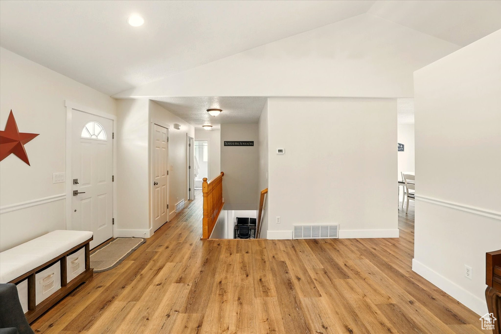Entrance foyer featuring light wood-type flooring, baseboards, lofted ceiling, and recessed lighting