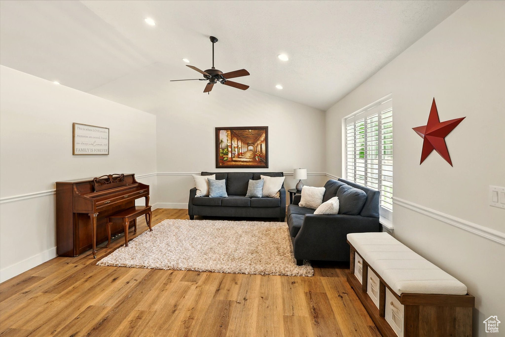 Living area with ceiling fan, recessed lighting, light wood-type flooring, lofted ceiling, and baseboards