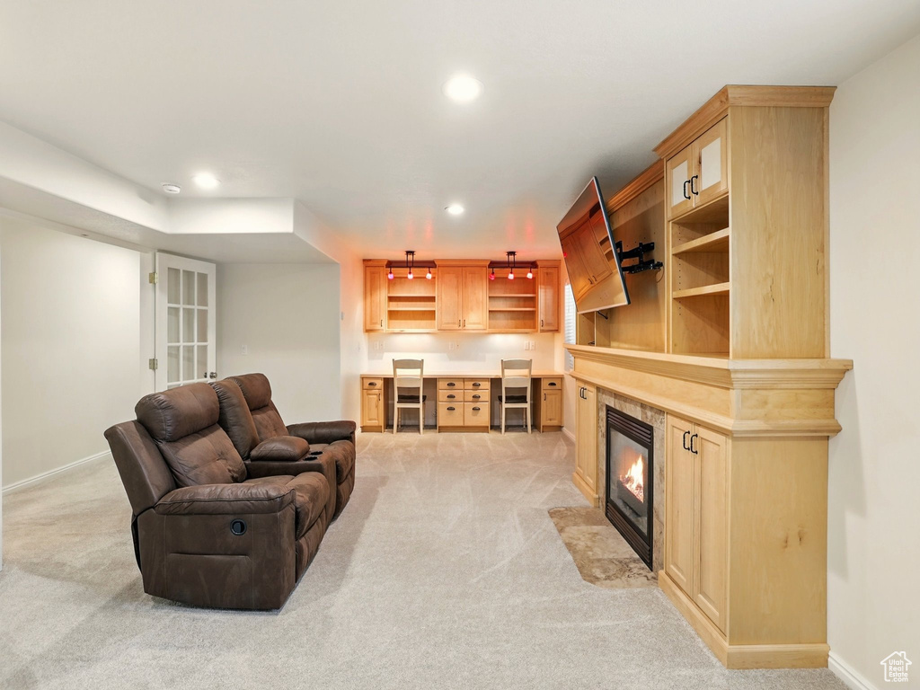 Living room with light carpet, recessed lighting, baseboards, and a tiled fireplace