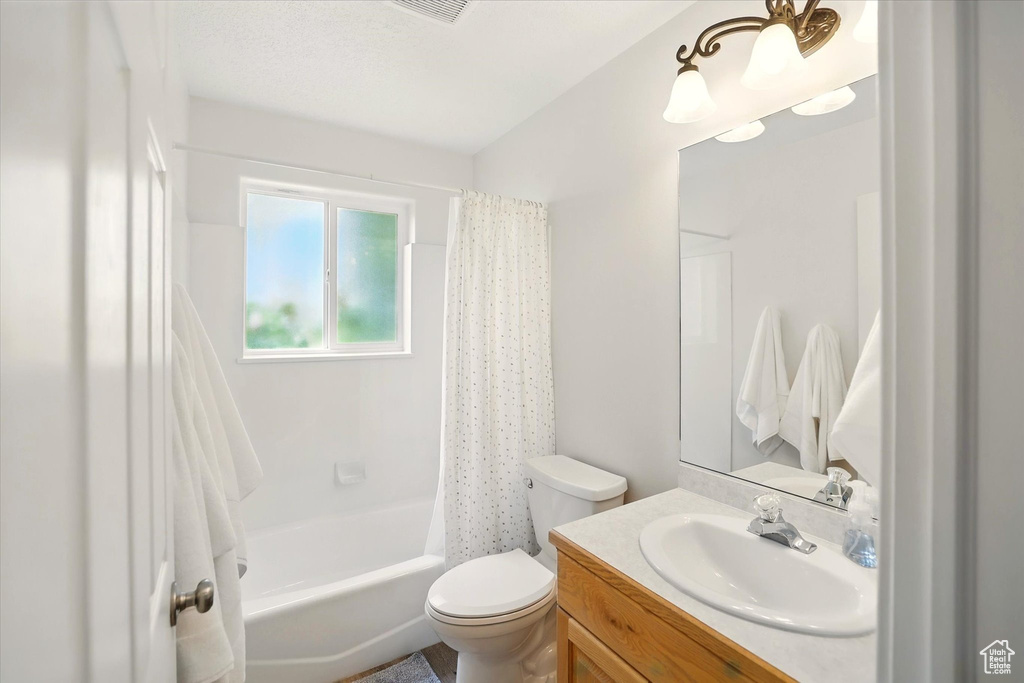 Full bath featuring toilet, vanity, and shower / tub combo with curtain