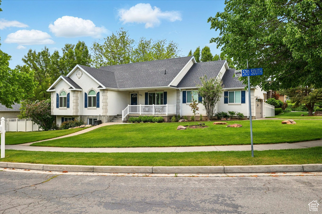 Single story home with a porch and a shingled roof