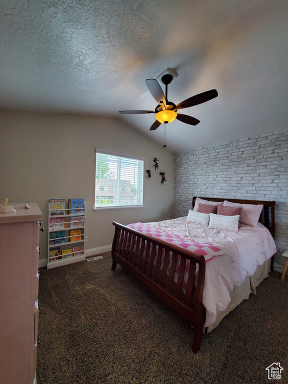 Carpeted bedroom featuring vaulted ceiling, a textured ceiling, baseboards, brick wall, and a ceiling fan