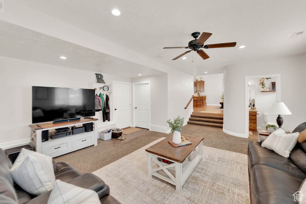 Living room with light colored carpet, recessed lighting, stairway, a ceiling fan, and baseboards