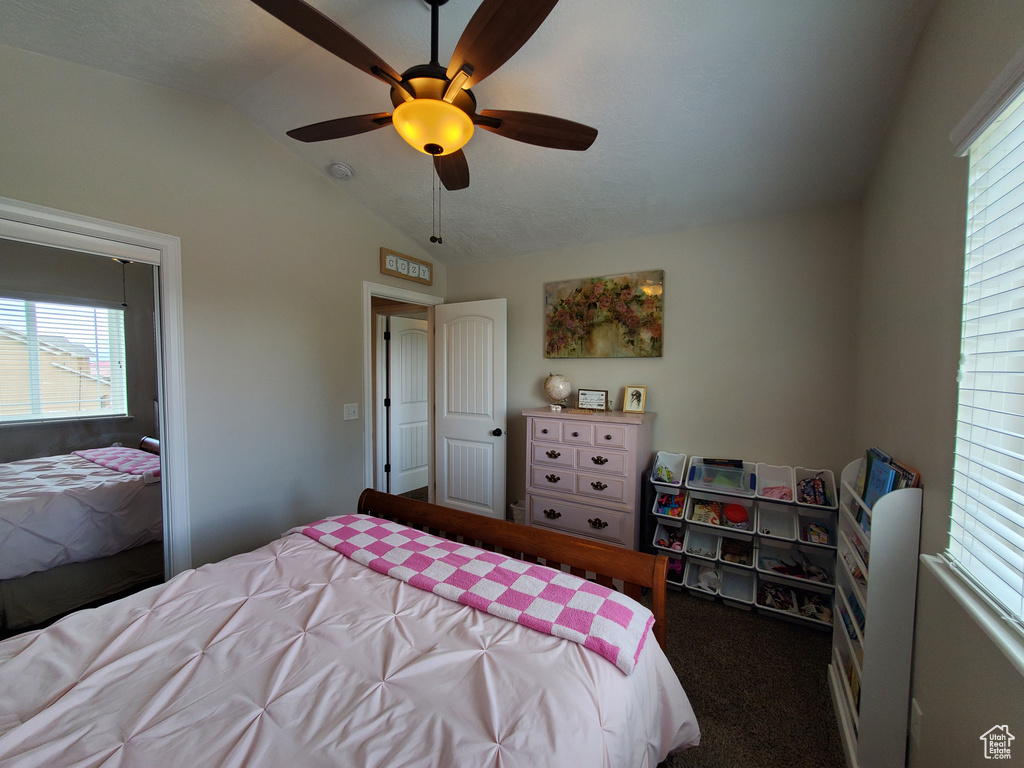Bedroom featuring vaulted ceiling, carpet floors, multiple windows, and ceiling fan
