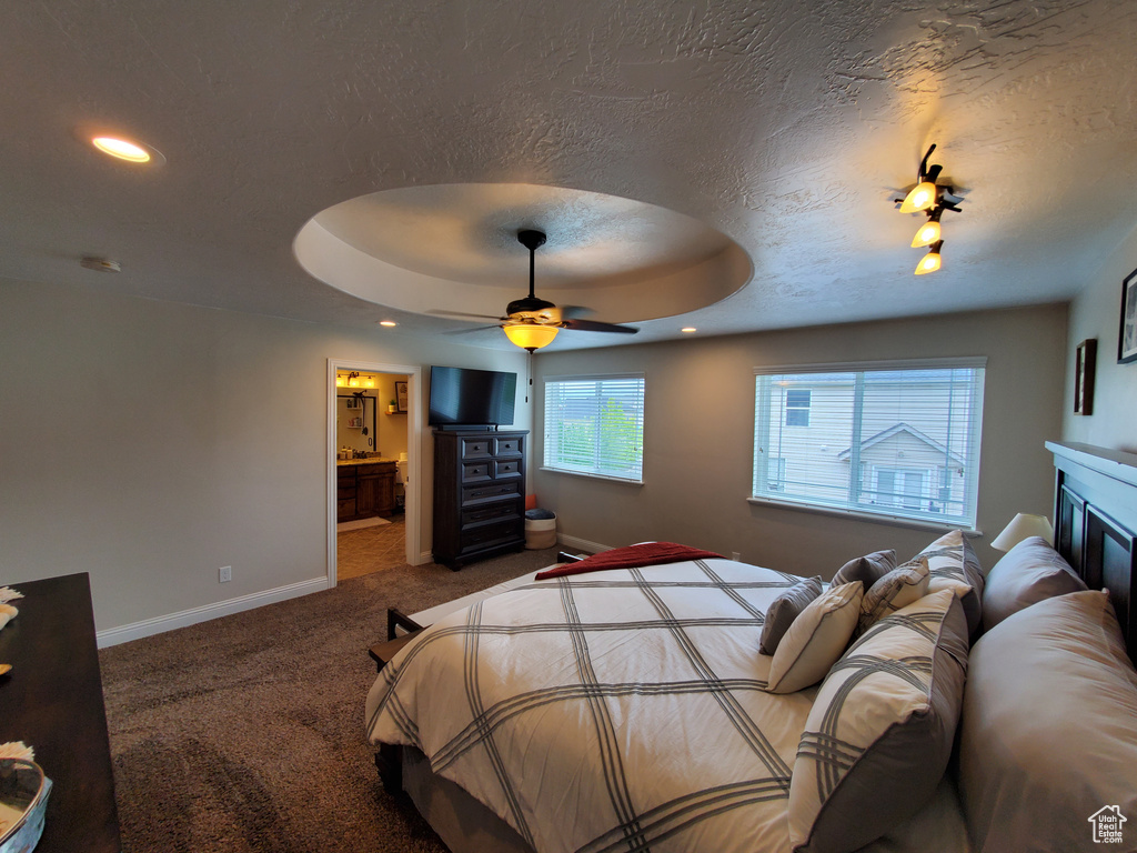 Bedroom with carpet flooring, baseboards, recessed lighting, a tray ceiling, and a textured ceiling