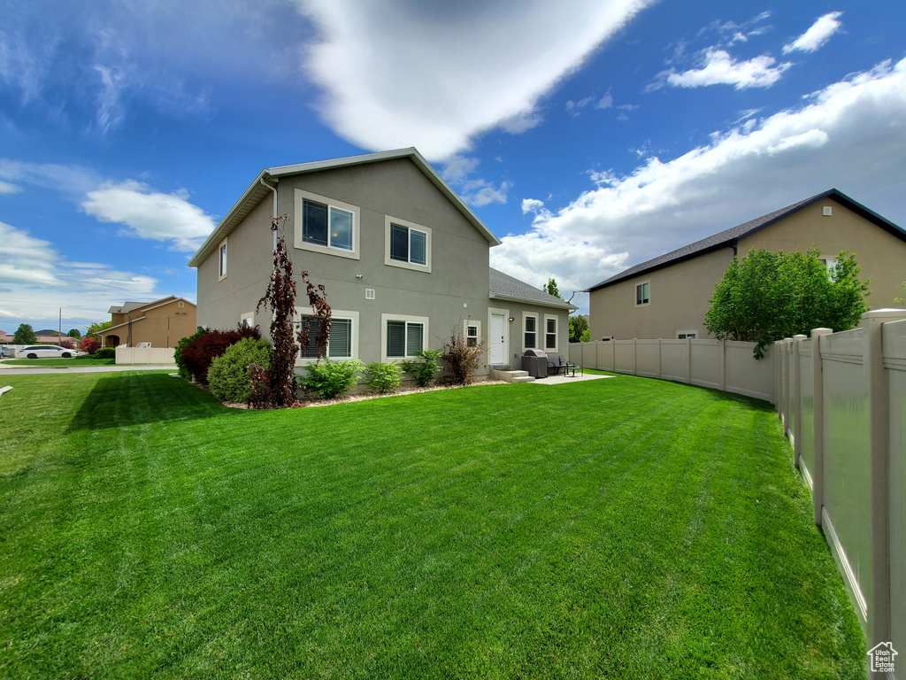 Rear view of house featuring stucco siding and a patio area