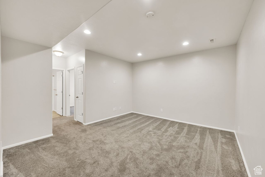 Carpeted spare room with baseboards, recessed lighting, and a smoke detector