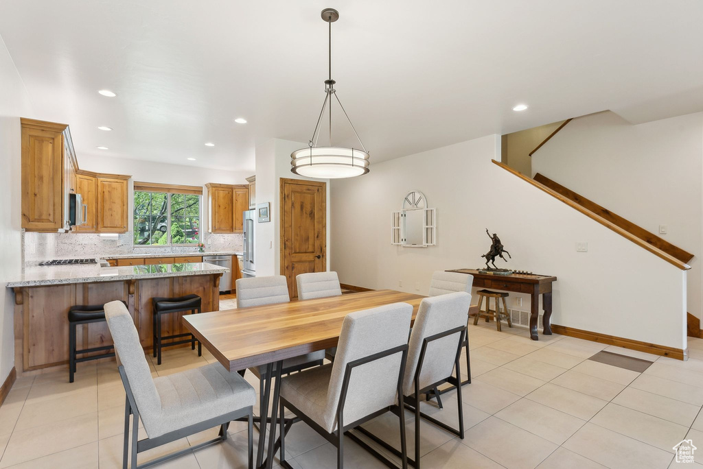 Dining space featuring recessed lighting, light tile patterned flooring, baseboards, and stairway
