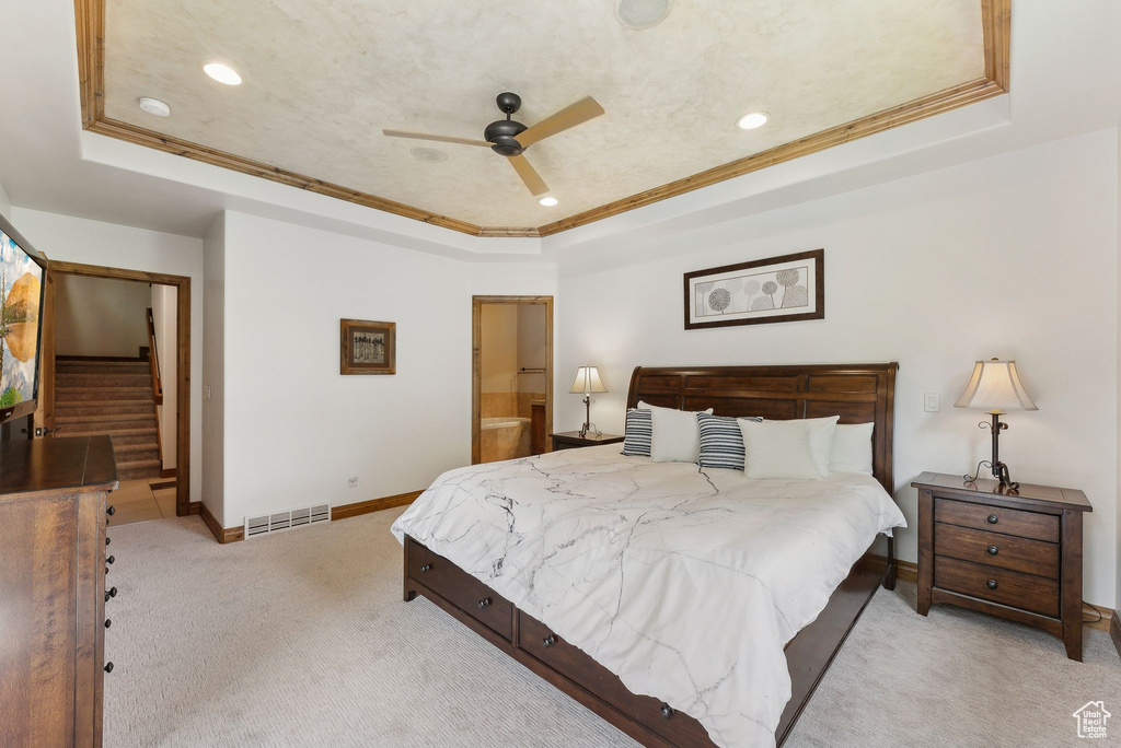 Bedroom with a raised ceiling, light carpet, crown molding, recessed lighting, and baseboards