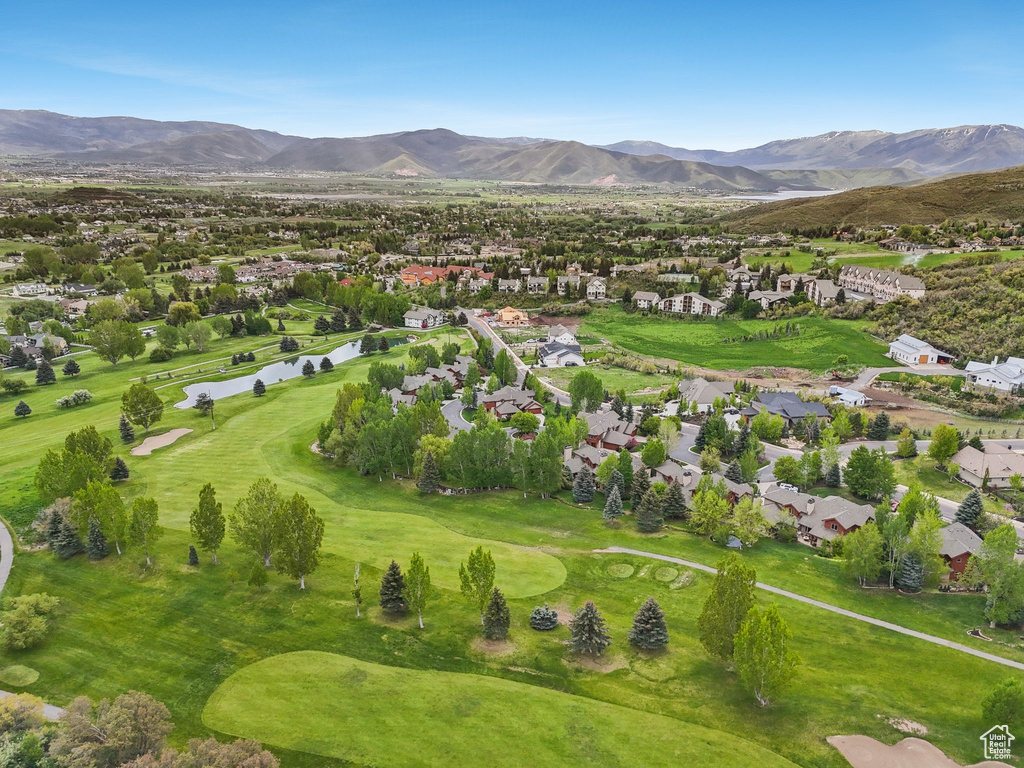 Aerial view of property\'s location with nearby suburban area, a local golf course, and a water and mountain view