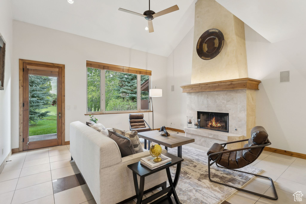Living area with high vaulted ceiling, light tile patterned floors, a fireplace, baseboards, and ceiling fan