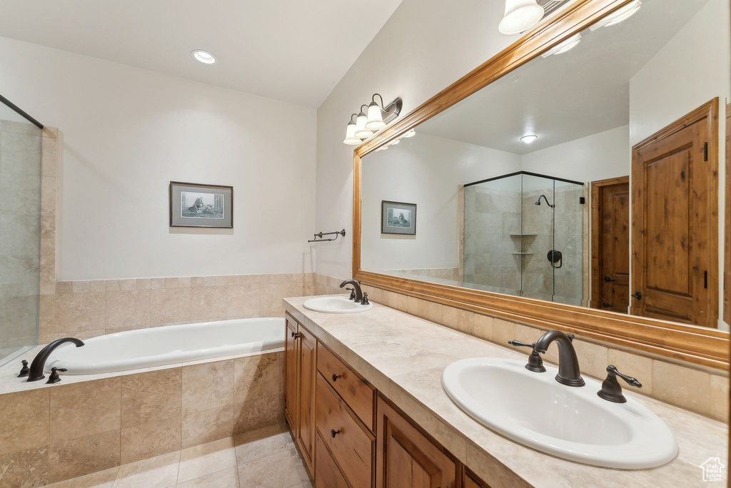 Bathroom featuring a shower stall, a garden tub, tile patterned flooring, and double vanity