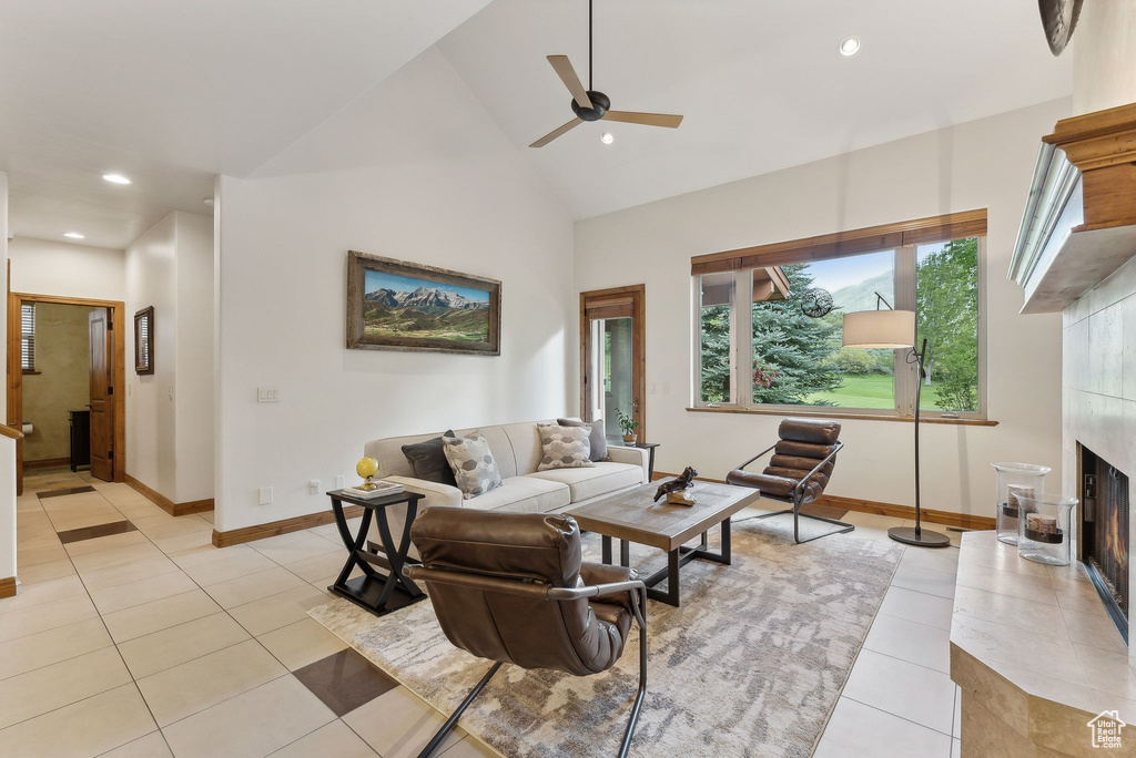 Living area with light tile patterned floors, a ceiling fan, a fireplace, recessed lighting, and baseboards