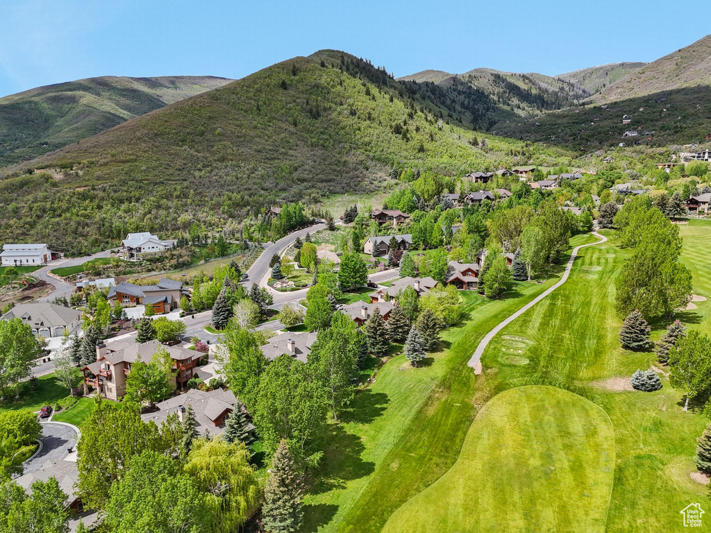 Aerial view of property\'s location featuring nearby suburban area, a mountain backdrop, and a local golf course