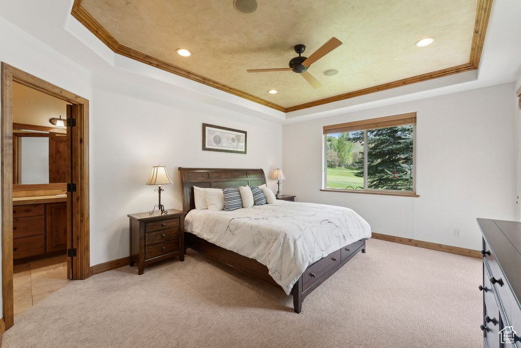 Bedroom featuring a raised ceiling, crown molding, light carpet, baseboards, and recessed lighting